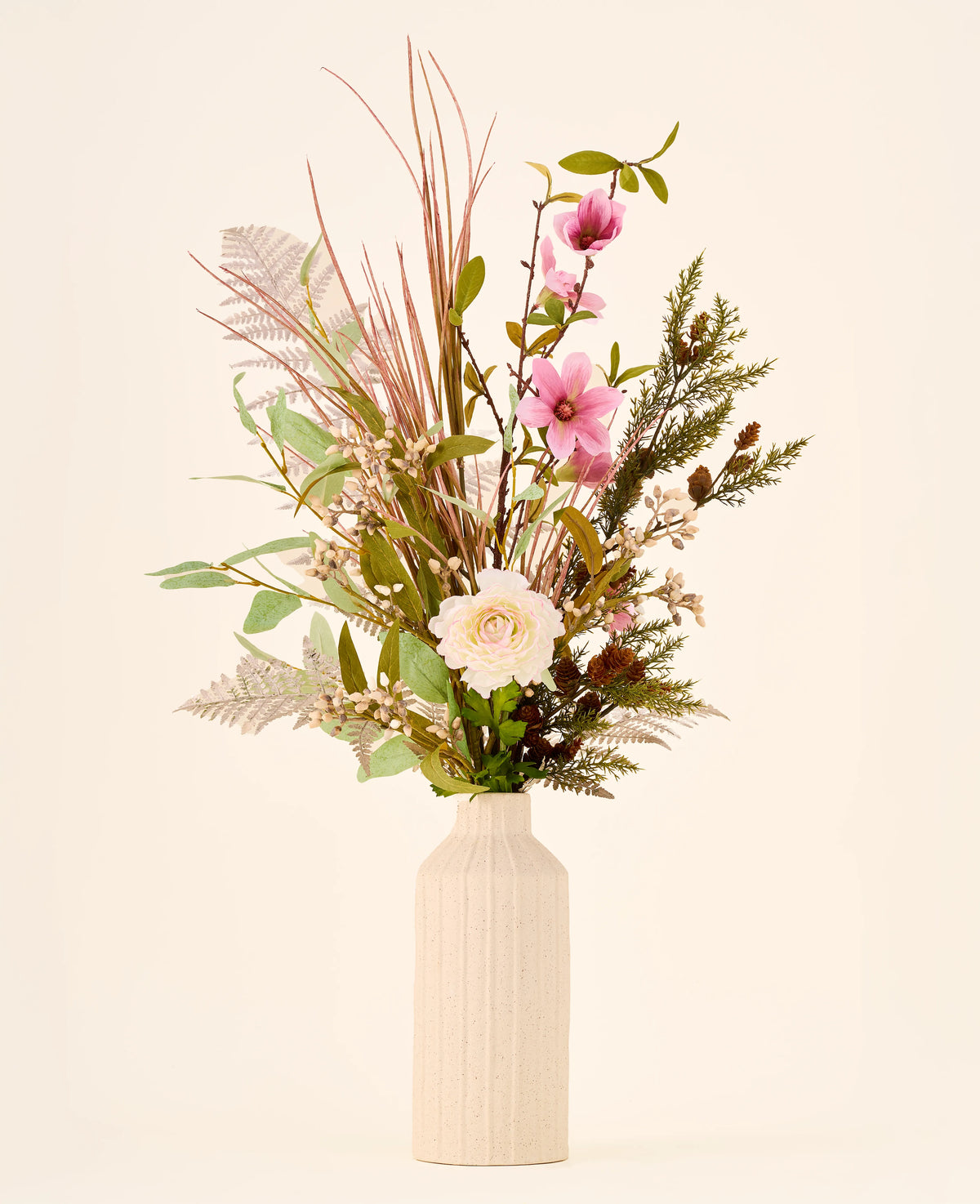 Zijden kunstbloemenboeket Frosted Blush met kunstbloemen in roze, witte bloesems, grassen en groen in een geribbelde beige vaas.