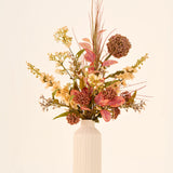 Een boeket van zijden kunstbloemen, Vintage Grace, samengesteld met onderhoudsvriendelijk kunstgroen in een hoge, gestructureerde, gebroken witte vaas.