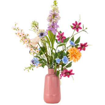 Een roze vaas van keramiek bevat een kleurrijk arrangement van kunstbloemen, waaronder paarse, blauwe, roze, oranje en witte bloemen met groene bladeren, tegen een witte achtergrond.