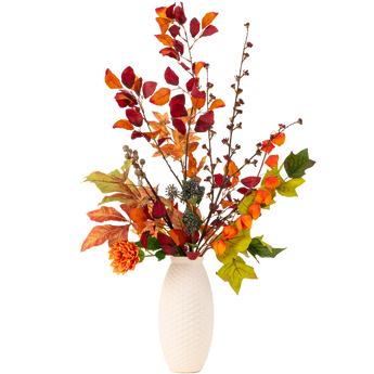 Een vaas met witte textuur bevat een arrangement van herfstbladeren, oranje bloemen en groen gebladerte op hoge takken, tegen een effen witte achtergrond.
