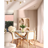 Een moderne eethoek heeft een ronde glazen tafel, houten stoelen met witte kussens en het Zijden kunstboeket Tulpen in vaas Wit als middelpunt. Decoratieve planken met vazen en transparante gordijnen maken de beige ruimte compleet.