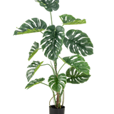 De Kunstplant Monstera 120 cm is een hoge faux monstera in pot met grote, glanzend groene bladeren met natuurlijk ogende gaten en scheuren, tegen een effen witte achtergrond.