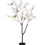 De Kunst Kersenbloesem 120 cm wit is een kunstboom in pot met donkerbruine takken, groene bladeren en trossen witte bloesembloemen tegen een effen witte achtergrond.