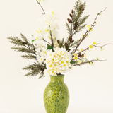 Het Zijden kunstbloemen boeket Earthlight is gearrangeerd in een vaas met groene structuur, met witte hortensia's, delicate witte bloesems en groenbruin gebladerte tegen een effen lichte achtergrond.