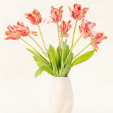 Een vaas met witte structuur toont het Zijden kunstbloemen boeket Franse Parkiet Tulp rood/geel, met levensechte rode en gele tulpen met groene bladeren tegen een effen lichte achtergrond.
