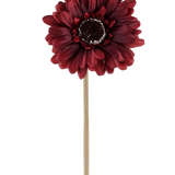 De Kunstbloem Gerbera 53 cm bordeaux bestaat uit één kunstgerbera in een rijke, donkerrode tint met gelaagde bloemblaadjes en een bruin hart, bevestigd aan een lange, rechte, lichtgekleurde steel en gepresenteerd tegen een effen witte achtergrond.