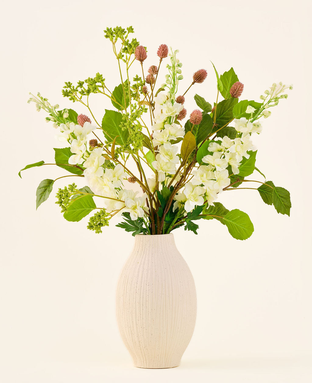 Zijden kunstbloemenboeket Pure Harmony, bestaande uit roze en witte bloemen met groene bladeren, geschikt in een geribbelde, crèmekleurige vaas.