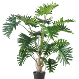 De Kunstplant Philodendron 180 cm heeft grote, glanzende, diep gelobde groene bladeren en is afgebeeld tegen een effen witte achtergrond.