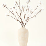 Het Zijden kunstbloemen boeket Kersenbloesem crème 114 cm staat hoog in een beige keramische vaas en brengt een serene decoratie in elke ruimte met zijn delicate, crèmekleurige takken tegen een lichte achtergrond.