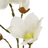 Close-up van de Kunst Magnolia Real Touch Wit 72cm: een bloeiende witte magnolia met zachte bloemblaadjes, geel hart, groene stelen en ongeopende knoppen aan de takken, tegen een witte achtergrond.
