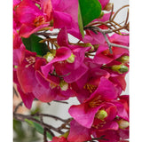 Close-up van de Kunstbloem Bougainvillea 90 cm paars, met levendige paarse bloemblaadjes, groene bladeren en dunne bruine stelen met gedetailleerde geelgroene hartjes voor een realistisch bloemenaccent.
