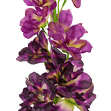 Een close-up van de Kunstbloem Delphinium Paars 79 cm, een hoge kunststengel met meerdere paarse en donkerpaarse bloemen met een groen en geel hart, tegen een witte achtergrond.
