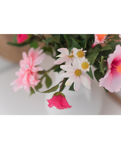 Een close-up van Kunstbloem Margriet 60 cm wit/roze toont roze en witte margrieten met een geel hart in een witte vaas tegen een neutrale achtergrond.