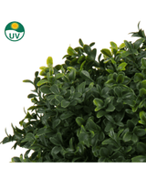 Close-up van dichte, groene Kunst Buxus op stam d60 cm bladeren met een UV-beschermingssymbool dat de weerstand van de plant tegen zonlicht toont.
