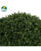 Een close-up van de Kunstplant Buxus op stam romeinse stijl 95cm toont dicht kunstgroen buxusblad met kleine blaadjes. In de linkerbovenhoek staat een UV-beschermend zonnesymbool.