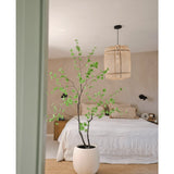 Een minimalistische slaapkamer met de Kunstplant Enkianthus 180 cm als grote potplant, een bed met wit beddengoed, een geweven hanglamp, beige muren en een vloerkleed van natuurvezel voor een eenvoudige en luchtige sfeer.