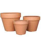 Drie lege Plantenbak Aegir-potten van terracotta in verschillende maten staan bij elkaar opgesteld tegen een witte achtergrond.