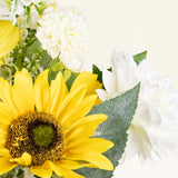 Een close-up van het Zijden kunstbloemen boeket Sunny Whisper met een heldergele zonnebloem, witte dahlia's en groene bladeren tegen een lichte, neutrale achtergrond.