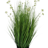 De Kunstgras Prei Bloem Ui Graspot 100cm brandvertragend is een kunstgrasplant in pot met lange, slanke sprieten en kleine witte bloemtrosjes in een zwarte ronde pot, afgebeeld tegen een effen witte achtergrond.