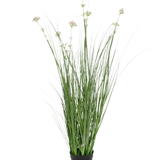 De Kunstgras Prei Bloem Uien Graspot 90cm brandvertragend heeft lange, dunne groene bladeren en bleke bloemtrossen in een zwarte pot, tegen een effen witte achtergrond.