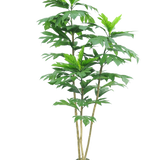De Kunstplant Nangka 180 cm is een hoge kunstplant met meerdere slanke bruine stengels en grote, glanzend groene bladeren in een kleine zwarte pot, afgebeeld tegen een effen witte achtergrond.