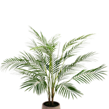 De Kunstpalm Chamaedorea 83 cm heeft lange, slanke groene bladeren en meerdere stelen in een lichtbruine pot met textuur, tegen een effen witte achtergrond.