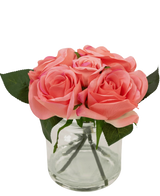 De Kunstrozenboeket Real Touch Roze 18cm heeft een kleine glazen vaas met levensechte roze rozen en groene bladeren, netjes gerangschikt om de stelen door het heldere glas te laten zien.
