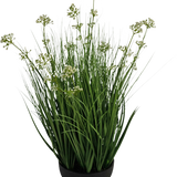 De Kunstgras Prei Bloem Ui Graspot 60cm brandvertragend heeft hoge, dunne grasachtige groene bladeren met kleine witte bloemtrosjes in een zwarte pot, tegen een witte achtergrond.